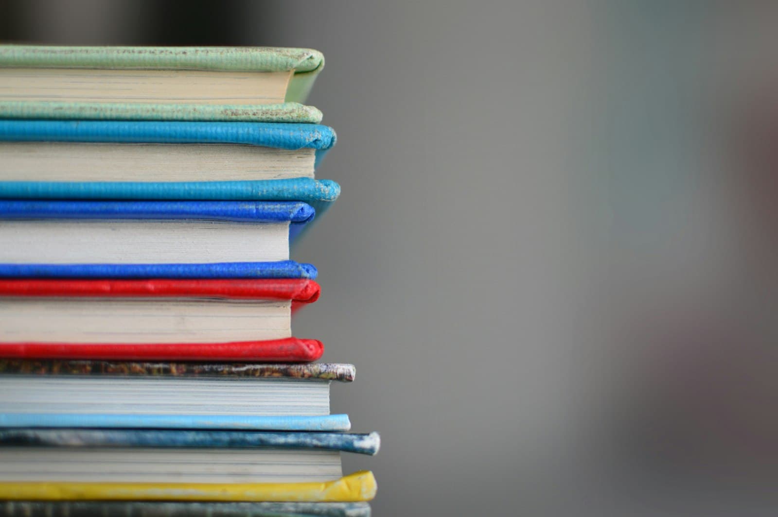 Stack of colourful textbooks with bright page edges