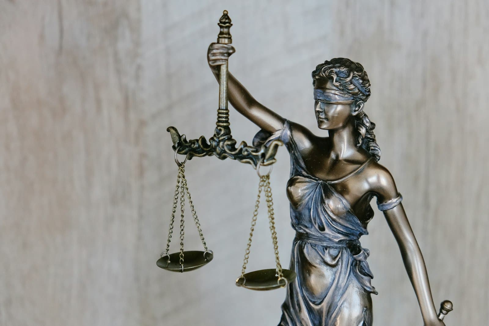 Bronze statue of blindfolded Lady Justice holding balanced scales